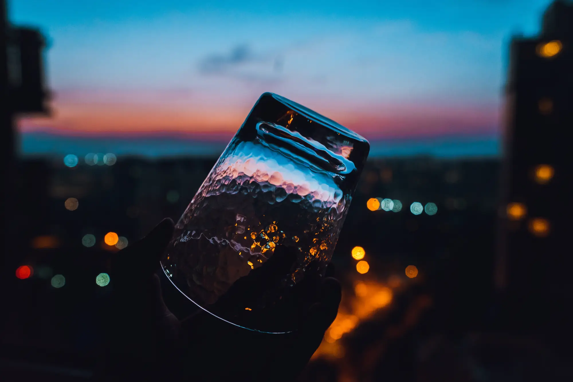 A glass of water on a windowsill at dusk