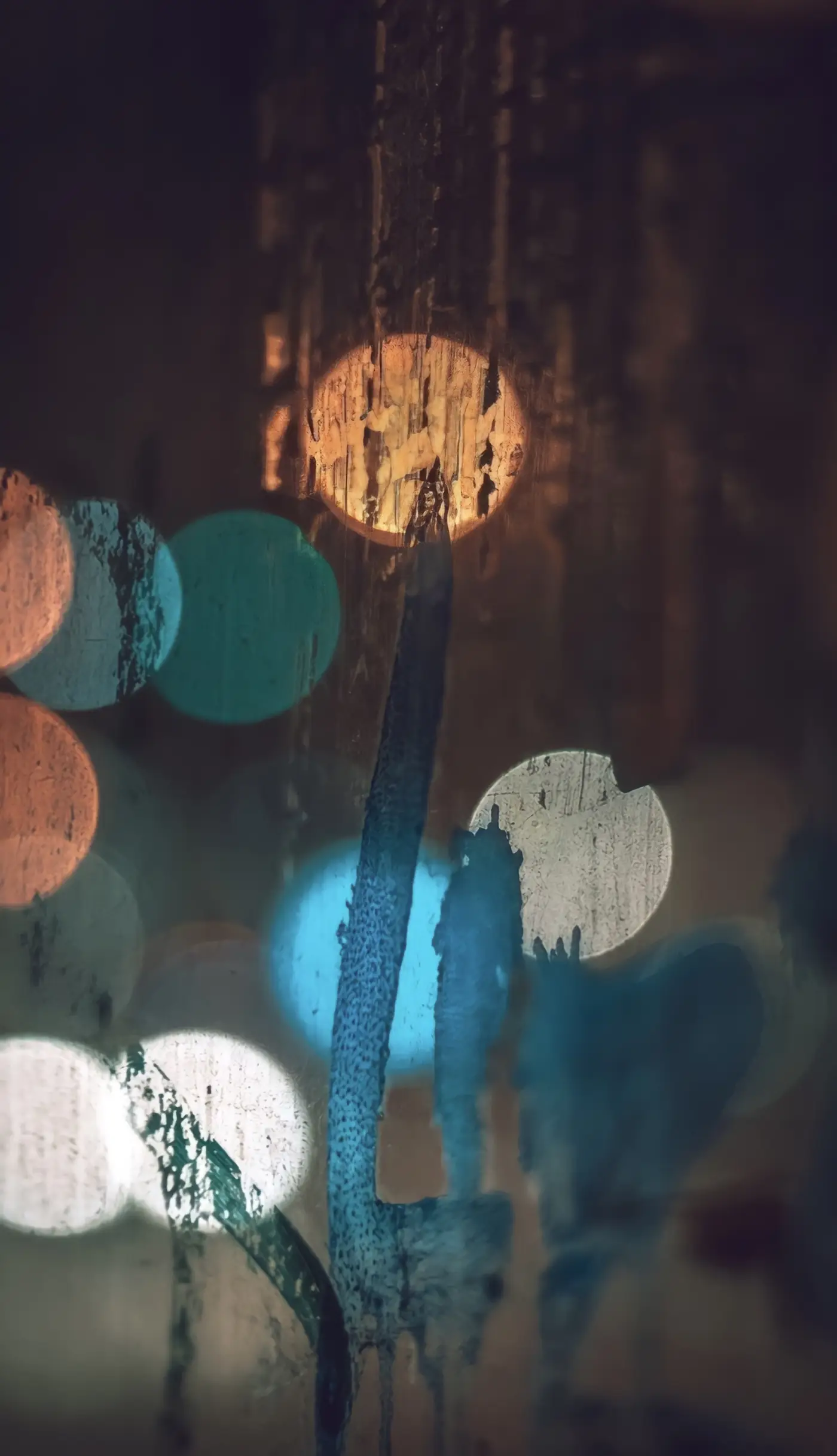 Rain on glass with soft out-of-focus lights behind it