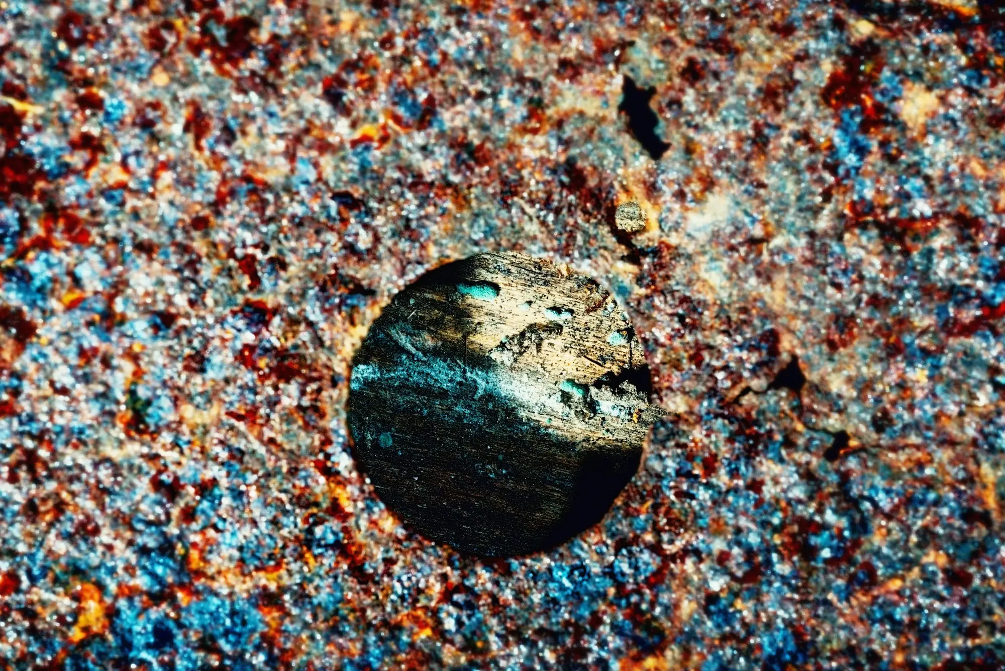 A weathered rust-coloured disc against a pale wall